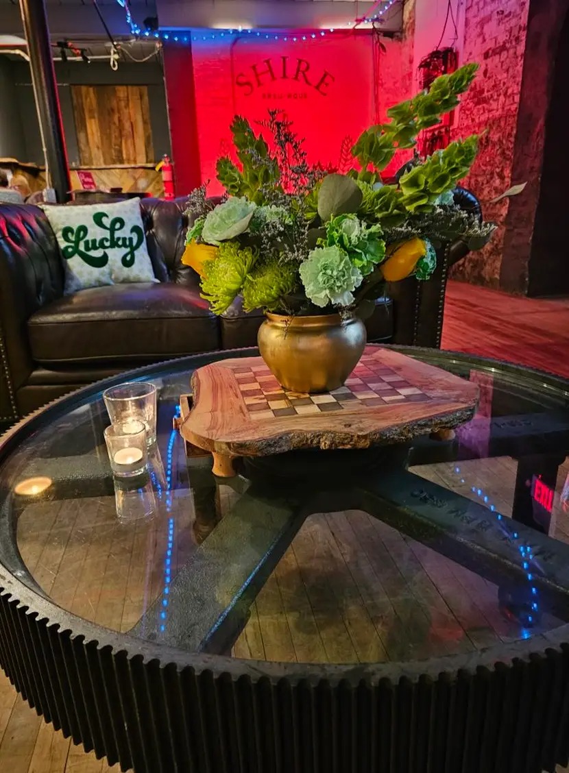 Glass coffee table with a decorative centerpiece and cozy seating in a warmly lit room.