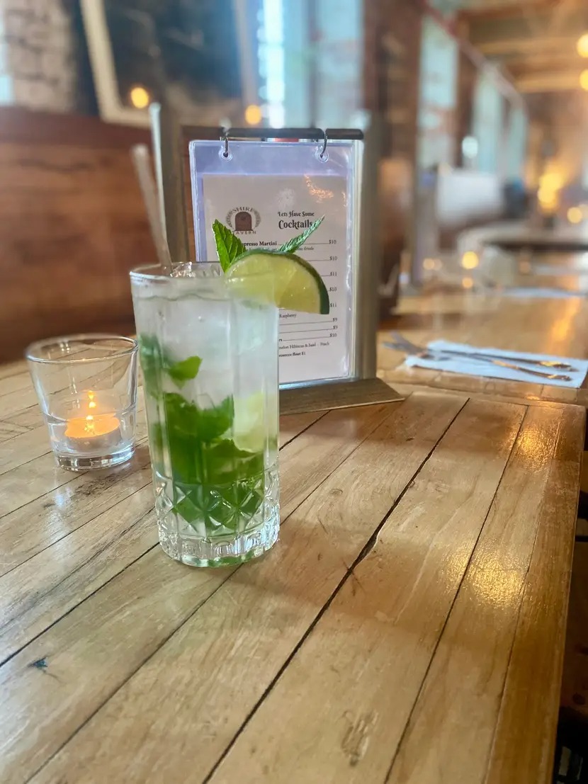 Refreshing mojito cocktail with lime and mint on wooden table.