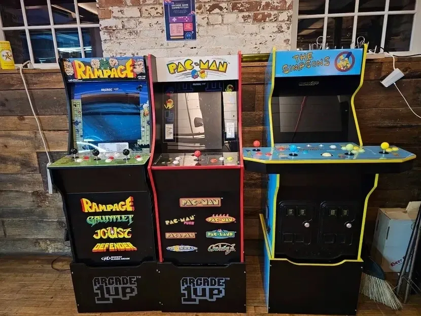 Three vintage arcade game machines lined up indoors.
