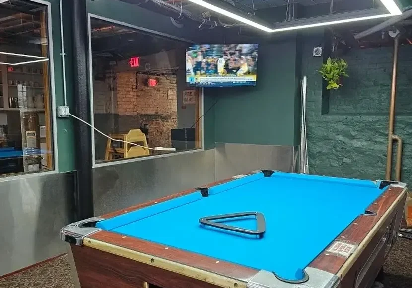 Indoor pool table setup with TV and seating area.